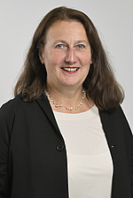 Irmtraud Sengschmied Pressefoto FC Johannes Zinner Foto einer Frau mit langen brünetten Haaren, sie trägt einen dunklen Blazer und ein weißes Top