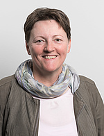 Rosalinde Pimon Porträtfoto, © Stefanie Luger Rosalinde Pimon trägt kurze Haare, eine weiße Bluse, eine braune Weste und einen hellgemusterten Schal um den Hals