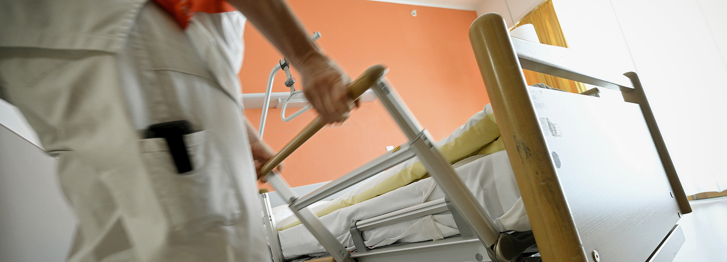 Vertretungsnetz Foto: eine Pflegekraft hantiert an den Seitenteilen eines Pflegebetts